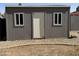 Exterior view of backyard shed with a gray paint job, two windows, and white door at 822 W El Alba Way, Chandler, AZ 85225