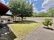 A spacious backyard features a covered patio and mature trees at 8402 N 105Th Ln, Peoria, AZ 85345