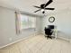 Comfortable bedroom featuring a ceiling fan, natural light, and neutral tile flooring at 8402 N 105Th Ln, Peoria, AZ 85345