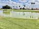 Tranquil golf course view featuring a water hazard, lush greenery, and sunny skies at 8402 N 105Th Ln, Peoria, AZ 85345