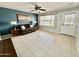 Bright living room featuring tile floors, a ceiling fan, and a view to the front yard at 8402 N 105Th Ln, Peoria, AZ 85345