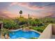 Aerial view of a backyard oasis, pool, lush desert landscape, mountains, and colorful sunset at 8526 E Hackamore Dr, Scottsdale, AZ 85255