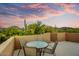 Balcony features a table and chairs with views of cacti, desert landscape and sunset at 8526 E Hackamore Dr, Scottsdale, AZ 85255