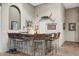 Elegant bar area with decorative items, granite countertop, and seating for a fun home entertainment at 8526 E Hackamore Dr, Scottsdale, AZ 85255