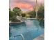 Inviting pool with a rock waterfall feature set amidst lush landscaping, creating a serene backyard oasis at 8526 E Hackamore Dr, Scottsdale, AZ 85255