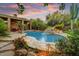 Beautiful backyard pool featuring a rock waterfall, surrounded by lush greenery and a covered patio at 8526 E Hackamore Dr, Scottsdale, AZ 85255