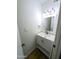 Small, neutral powder room with a sink, white vanity, and modern lighting fixtures at 8558 E Indian School Rd # A, Scottsdale, AZ 85251