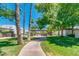 Lush courtyard with a walkway, palm trees, green grass, and shaded seating areas at 8558 E Indian School Rd # A, Scottsdale, AZ 85251