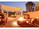 Outdoor kitchen with pergola, gas grill, fire pit and lounge chairs on the patio at 9231 W Bent Tree Dr, Peoria, AZ 85383