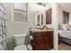 Bathroom with a vanity featuring granite countertops and dark wood cabinets, alongside a toilet and window at 9231 W Bent Tree Dr, Peoria, AZ 85383