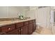 A full bathroom with a double sink vanity with granite counters, tiled floors and shower at 9231 W Bent Tree Dr, Peoria, AZ 85383