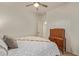 Bedroom with neutral carpet, ceiling fan, and a comfortable-looking bed with decorative pillows, and dresser at 9231 W Bent Tree Dr, Peoria, AZ 85383