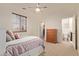 Cozy bedroom with neutral carpet, ceiling fan, and a view of the bathroom and walk-in closet at 9231 W Bent Tree Dr, Peoria, AZ 85383