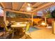 Outdoor kitchen and dining area with a built-in grill, stone countertops, and cozy fire pit for outdoor gatherings at 9231 W Bent Tree Dr, Peoria, AZ 85383