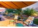 Inviting outdoor patio with comfortable seating, lush landscaping, and elegant lighting for evening relaxation at 9231 W Bent Tree Dr, Peoria, AZ 85383