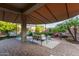 Spacious covered patio with comfortable seating, lush landscaping, and a charming water feature at 9231 W Bent Tree Dr, Peoria, AZ 85383
