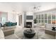 Bright living room featuring a fireplace, neutral decor, plantation shutters, and modern furnishings at 9550 E Thunderbird Rd # 259, Scottsdale, AZ 85260