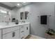 Bathroom with double vanity, quartz countertop, modern fixtures, and a large mirror at 9570 W Whispering Wind Dr, Peoria, AZ 85383
