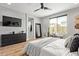 Stylish bedroom with wood-look flooring, wall-mounted TV, and large window with natural light at 9570 W Whispering Wind Dr, Peoria, AZ 85383