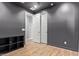 This bedroom features modern sliding closet doors, wood-look floors, and dark gray walls at 9570 W Whispering Wind Dr, Peoria, AZ 85383