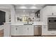 Bright kitchen with white cabinets, quartz countertops, and an open view to the living room at 9570 W Whispering Wind Dr, Peoria, AZ 85383