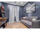 The bonus room features a large painting and a comfortable gray couch at 9570 W Whispering Wind Dr, Peoria, AZ 85383
