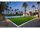 Nighttime backyard scene highlighting the well-lit landscaping around the lounge, house and sports court at 9733 E Clinton St, Scottsdale, AZ 85260