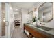 Bright bathroom featuring modern double vanity, unique mirrors, and an open doorway to the bedroom at 9733 E Clinton St, Scottsdale, AZ 85260