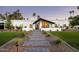 Stunning modern home with a white exterior, a black roof, and a beautifully landscaped front yard at 9733 E Clinton St, Scottsdale, AZ 85260