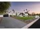 Modern home showcasing a well-manicured lawn, sleek design, and a paved driveway at 9733 E Clinton St, Scottsdale, AZ 85260
