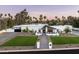 Eye-level view of a modern white home boasting palm trees, manicured lawn, and a stylish walkway to the entrance at 9733 E Clinton St, Scottsdale, AZ 85260