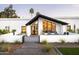 Modern home with dramatic architecture and a beautifully designed entrance framed by lush landscaping and modern lighting at 9733 E Clinton St, Scottsdale, AZ 85260