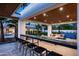 Stunning outdoor bar with seating, offering views of the well-manicured lawn, sports court, and lounge at 9733 E Clinton St, Scottsdale, AZ 85260