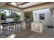 Outdoor kitchen featuring a built-in BBQ, bar seating, and modern lighting at 9733 E Clinton St, Scottsdale, AZ 85260