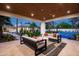 Outdoor seating with plush sofas and decorative pillows, with the sports court in the background at 9733 E Clinton St, Scottsdale, AZ 85260