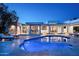 Modern backyard pool and spa featuring travertine tile and a covered patio with seating at 9733 E Clinton St, Scottsdale, AZ 85260