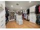 Spacious walk-in closet featuring custom shelving, ample storage, and hardwood flooring at 9733 E Clinton St, Scottsdale, AZ 85260