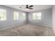 Bright bedroom with three windows, neutral carpet, and a ceiling fan for comfort at 10055 E Isabella Ave, Mesa, AZ 85209