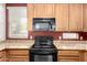 Close up of a kitchen with black appliances, wood cabinetry, and granite countertops at 10055 E Isabella Ave, Mesa, AZ 85209