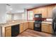 Well-lit kitchen featuring wooden cabinets, granite countertops, and modern black appliances at 10055 E Isabella Ave, Mesa, AZ 85209