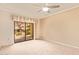 Bright bedroom with a ceiling fan and sliding glass doors leading to a private outdoor view at 10330 W Thunderbird W Blvd # B103, Sun City, AZ 85351