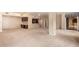 Spacious living room with an open floorplan, neutral carpeting, and access to the kitchen and outdoor balcony at 10330 W Thunderbird W Blvd # B103, Sun City, AZ 85351