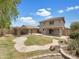 Expansive backyard featuring a covered patio, lush lawn, and a rock and desert landscape design at 1078 E Poncho Ln, San Tan Valley, AZ 85143