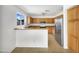 Well-lit kitchen with wood cabinets, stainless steel refrigerator, and tiled floors at 1078 E Poncho Ln, San Tan Valley, AZ 85143