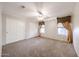 Bedroom featuring neutral carpeting, ceiling fan, and a window with decorative curtains at 11034 W Sierra Pinta Dr, Peoria, AZ 85373