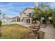 Spacious backyard with a covered patio, balcony, pool, stone fountain, and well-manicured lawn at 1146 W Sea Fog Dr, Gilbert, AZ 85233