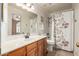 Neutral bathroom featuring wood vanity, a decorative shower curtain, and an arched window at 1146 W Sea Fog Dr, Gilbert, AZ 85233