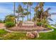 Community entrance sign featuring palm trees, flowers, and landscaping, creating a welcoming atmosphere at 1146 W Sea Fog Dr, Gilbert, AZ 85233