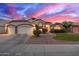 Charming home showcasing a well-manicured front yard and an attached two-car garage under a colorful dusk sky at 1146 W Sea Fog Dr, Gilbert, AZ 85233