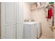 Bright laundry room featuring a washer and dryer, tiled floors, and a closet space for storage at 1146 W Sea Fog Dr, Gilbert, AZ 85233